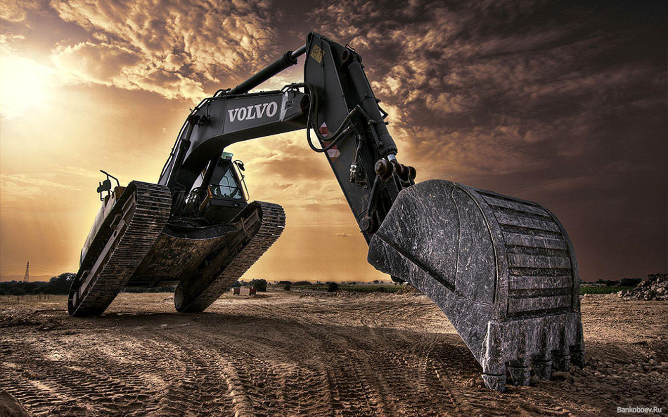 Volvo Excavator in the sun shine and clouds, lifting front tracks from the ground